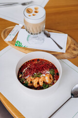 Appetizing Thai food of pumpkin porridge with shrimps served with greens and seeds in restaurant