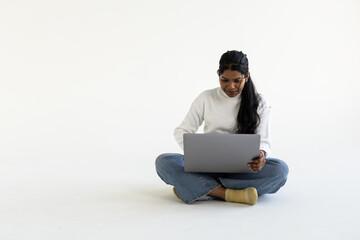 Indian woman or employee using laptop on white background.