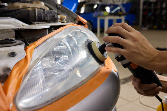 Big headlight cleaning on the car with power buffer machine at service station ,Before and after cleaning