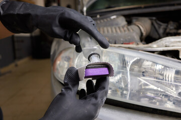 Car detailing - Man applies protective coating to the car. Selective focus.