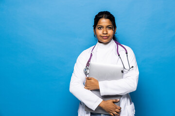 Cheerful young attractive hindu woman medical worker in uniform works at computer isolated on white background.