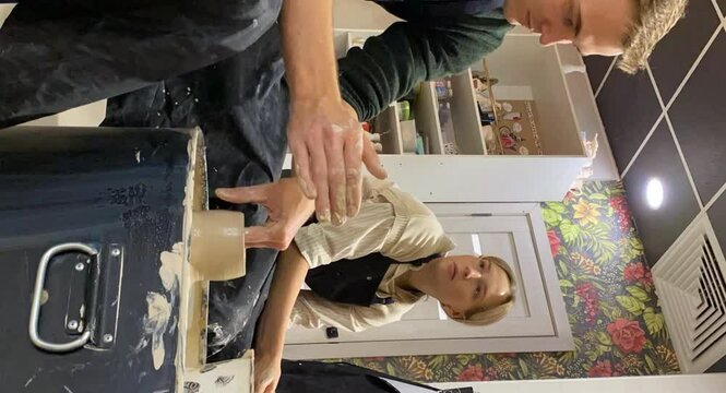 A couple of young people on a date to create mugs from clay. Time lapse. clay modeling process Vertical video.