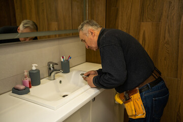 Man repair and fixing leaky faucet in bathroom.