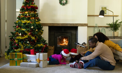 African american family spending time together in living room at christmas at home, copy space