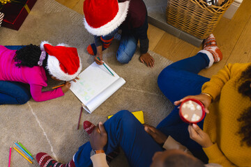 African american family spending time together in living room at christmas at home, copy space