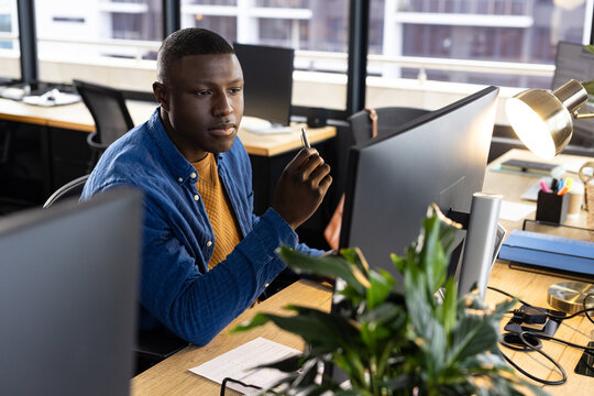 Focused African American Casual Businessman Sitting At Desk Using Computer In Office, Copy Space