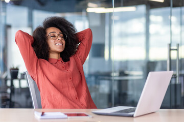 Woman well done successfully completed the work, businesswoman joyful , satisfied at the workplace, hands behind head, rests, dreams and visualizes the future results achievement