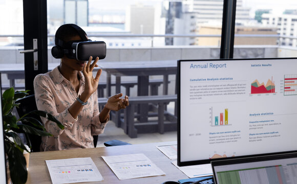 African american casual businesswoman wearing vr headset using virtual interface at desk, copy space