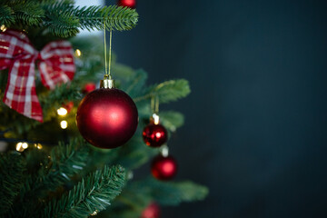 Banner of beautiful fir branches in red tones with shiny ball, christmas decorations and lights. Copy space, template, postcard. Home decoration. Seasonal Holidays, December 25