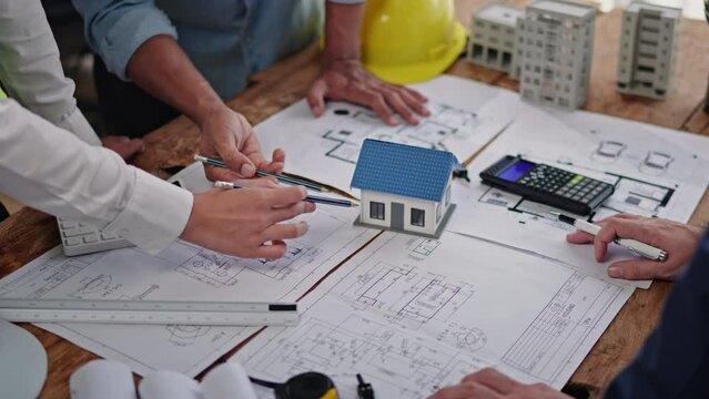Close up of hands working brainstorming and measuring for cost estimating on paperworks and floor plan drawings about design architectural and engineering for houses and buildings.