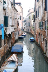 Fototapeta na wymiar A vertical view of a small random canal in Venice. Italy - November 13, 2023.