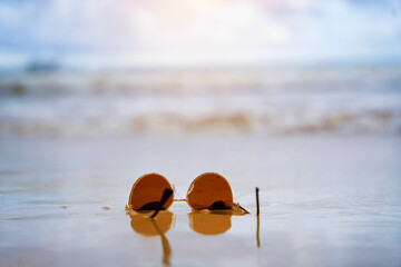 Sunglasses in the waves of the warm sea on vacation, a paradise beach and beautiful sunglasses in...