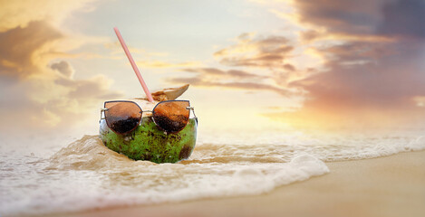 Juicy coconut stands in the waves of the warm sea, cheerful coconut on vacation, a paradise beach...