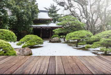 Wooden table top with blurred garden and japan house.