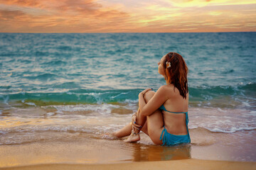 A beautiful girl in a bikini on a wild beach, bathing in the clear waves of the warm sea. a heavenly place and a beautiful model.