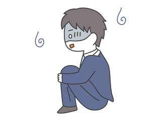 体育座りをしながら悩んでいるスーツの男性