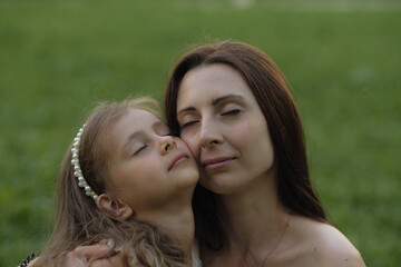 A woman and young girl, relaxing in nature's embrace, exude calmness and a strong family bond. It's a testament to the growing trend of mindfulness and togetherness.