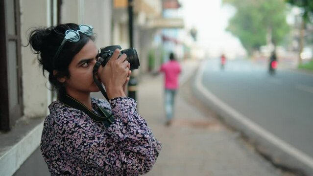 Professional Indian woman photographer capturing the local city streets with her professional DSLR camera.