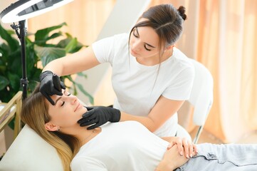 Eyebrows tattoo or Permanent Makeup. Beauty eyebrow upgrade procedure.