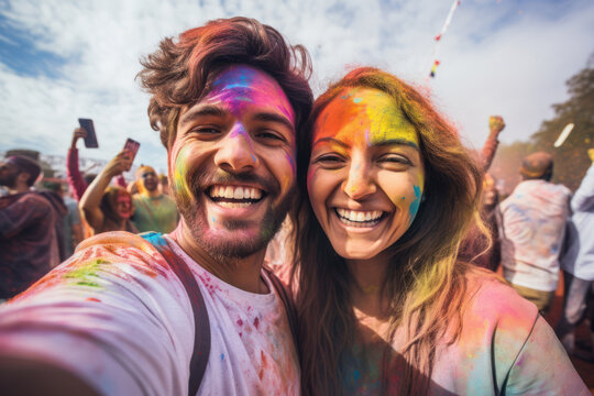 happy couple taking selfie together at Holi festival
