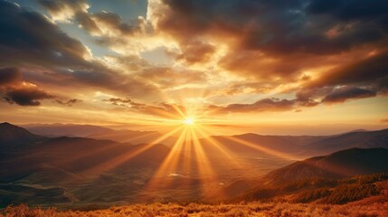 Golden sundown behind the mountains with lots of sun rays in the dramatic sky