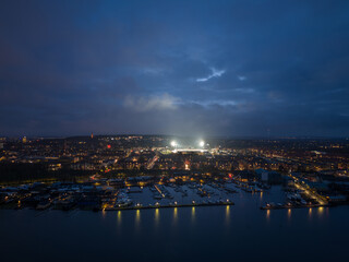 Aerial panoramic night  skyline cityscape of Vestbyen city district in Aalborg during football game at the illuminated stadium. North Jutland Region, Denmark. 