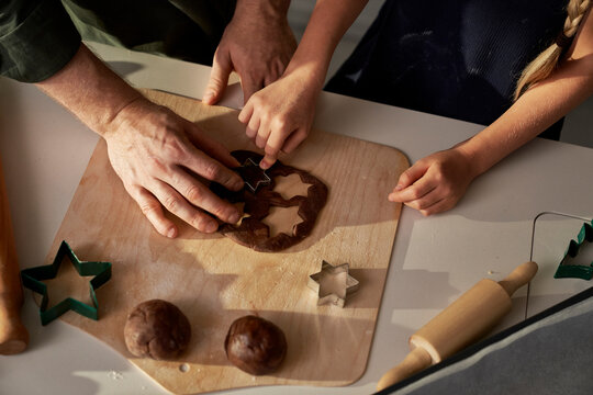 Unrecognizable caucasian father and daughter making gingerbreads in domestic kitchen - Powered by Adobe