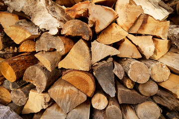 Stack of firewood logs, cut woodpile for fuel and heating, natural timber texture background
