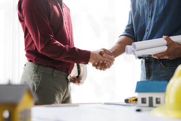 Engineer and contractor shaking hands success of the project work together.