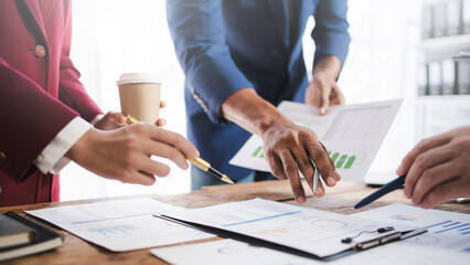 Close up of hands business people working together in boardroom, brainstorming, discussing and analyzing and planning business strategy.