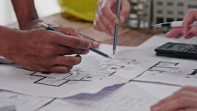Close up of hands working brainstorming and measuring for cost estimating on paperworks and floor plan drawings about design architectural and engineering for houses and buildings.