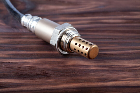 Oxygen sensor for gasoline and diesel engines on wooden table. lambda probe is reliable component to optimize your car's performance