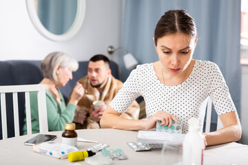 Fototapeta premium Young wife carefully reads the annotation for medicines and checks the information on the Internet