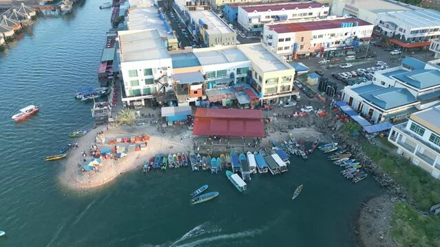 Aerial view of rich marine life of the Sabah Semporna Bajau Laut community, Malaysia. Residential settlement with boats and people on the beach.