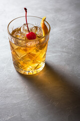 Old fashion cocktail on a grey background. 