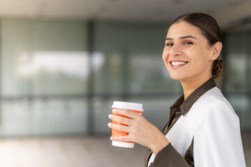 young business woman taking a break outside and drinking coffee