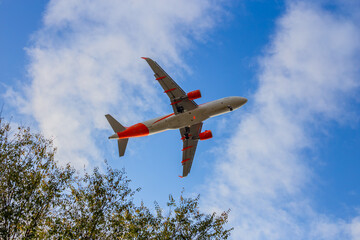 Passenger airplane. Low flying plane on the background of sky. Passenger Airplane Taking Off Into The Blue Sky. Linate Airport. Italia, Lombardia, San Donato Milanese