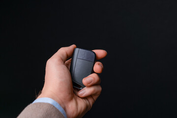 Car sales man handing over car keys for new electric car, to buyer. with black background in studio...