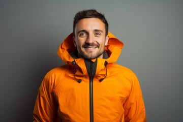 Obraz premium Portrait of a happy man in his 30s wearing a windproof softshell against a modern minimalist interior. AI Generation