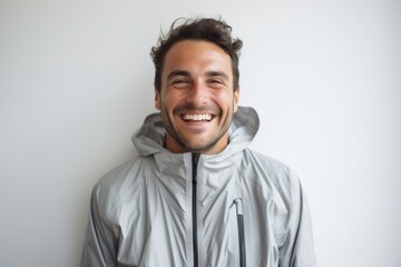 Obraz premium Portrait of a happy man in his 30s wearing a windproof softshell against a modern minimalist interior. AI Generation