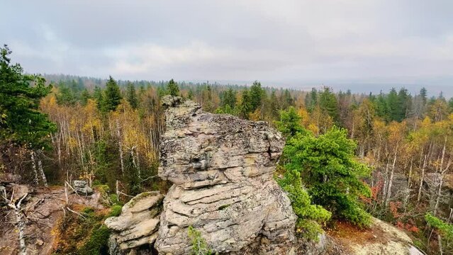 Stone City in autumn. Bright foliage and autumn landscape. The natural landscape is a rock formation in Central Russia, the Urals. A natural monument. Ancient rocky folding in the Ural Mountains. 4K