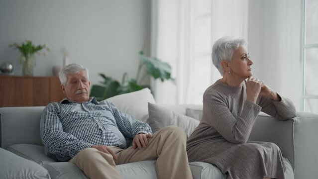 Senior sad couple separate on couch ignoring each other, avoid talking after fight and quarrel. Wife and husband have misunderstandings, experiencing relationship crisis. Upset elderly family at home.