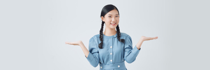 Asian cute girl smiling and showing hand to present something isolated on white background.