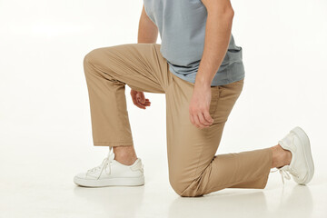 casual man standing on his knees on white studio background