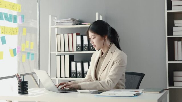 Asian woman sitting in the office, businesswoman managing a startup company, planning marketing and finding ways to increase profits, managing sales growth, strategizing the company.