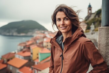 Fototapeta na wymiar Portrait of a blissful woman in her 40s wearing a lightweight packable anorak against a picturesque seaside village. AI Generation