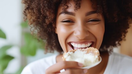 Naklejka premium Young beautiful african woman eating a cake with cream closeup