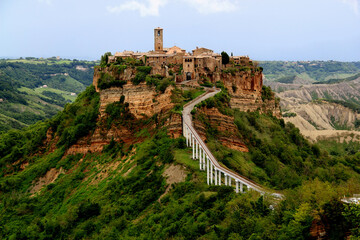 View of the valley and town of Civita di Bagnoregio with stone houses on a high cliff in the...