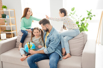 Photo of four people handsome guy cute little girl sit on couch touch globe help with geography weekend indoors