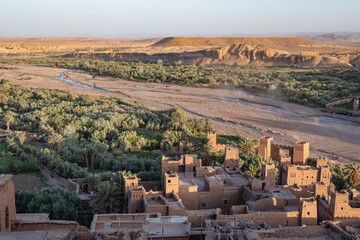 Oasis town of Ait Benhaddou next to an oasis with palm trees in the Moroccan Sahara Desert